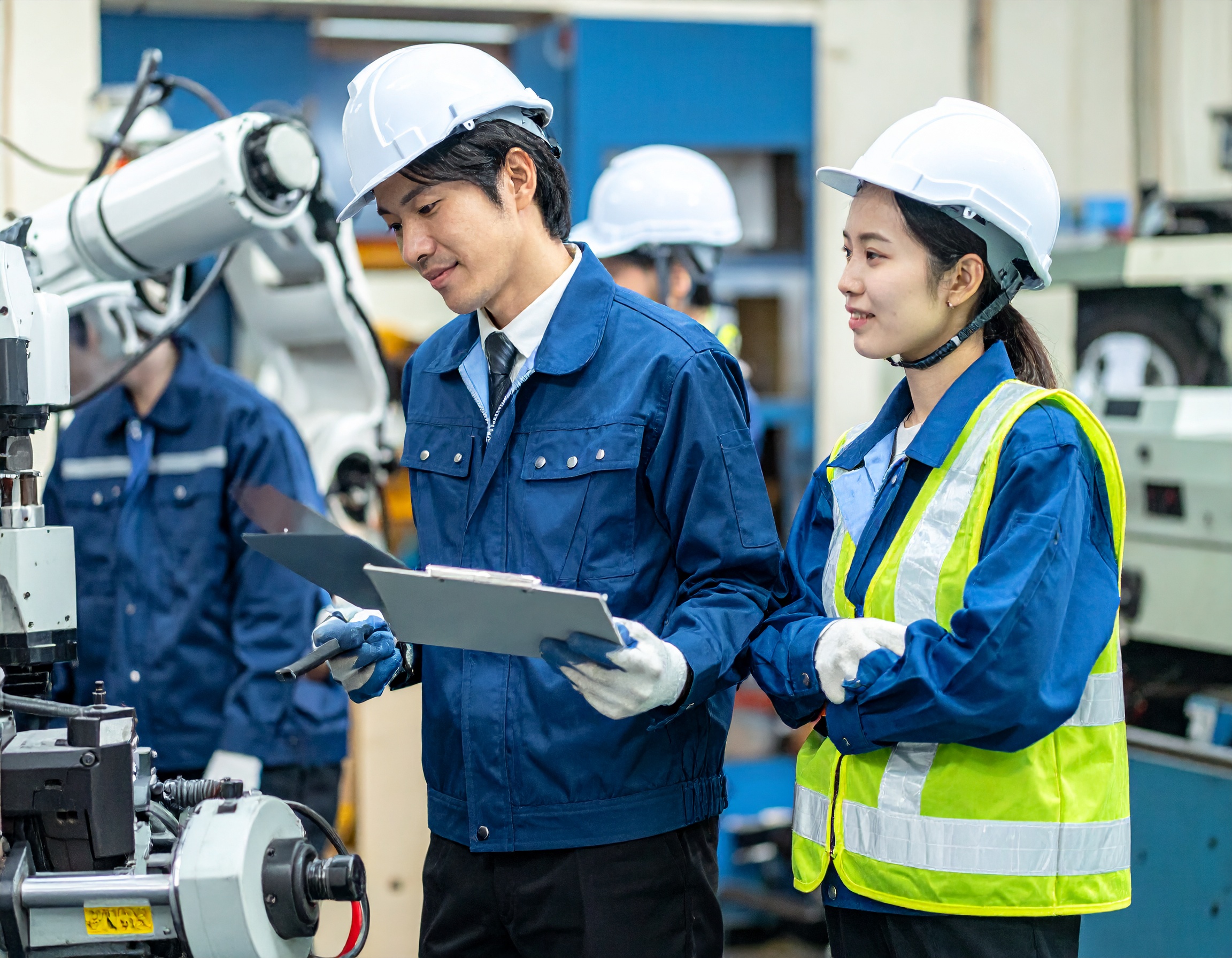 設備管理の現場で働く日本人男性と女性。 機械室や設備点検の現場で真剣に業務を行っている様子。